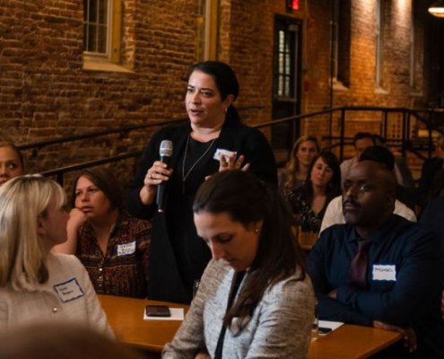 woman in event crowd holding microphone speaking